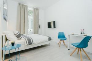 a bedroom with a bed and two blue chairs at SIA Downtown Apartments in Zagreb