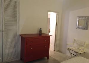 - une chambre avec une commode, une chaise et un miroir dans l'établissement Residenza Khaddiuggia, à Pantelleria