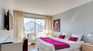 a bedroom with a large bed and a large window at Hotel Sable Et Soleil - Port, Plage et spa in Fréjus