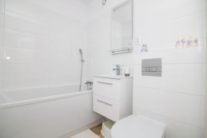 ヘルにあるApartament Lauraのトイレと浴槽を備えた白いバスルーム +22枚の写真
