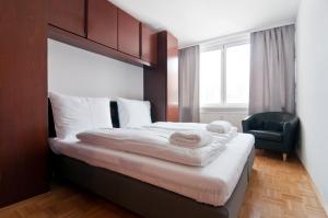 ウィーンにあるTop Location Vienna Marchettiのベッドルーム(大型ベッド1台、黒い椅子付)