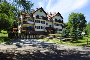 duży dom z płotem przed nim w obiekcie Klimatyczne Apartamenty Sun Seasons 24 w Szklarskiej Porębie by Noclegi Renters w Szklarskiej Porębie