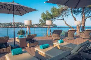 a deck with chairs and umbrellas overlooking the water at Iberostar Selection Jardín del Sol Suites - Adults Only in Santa Ponsa