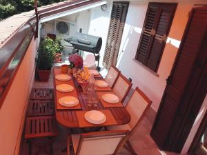 - une table en bois sur un balcon avec des chaises et un grill dans l'établissement LaPanoramica, à Baveno