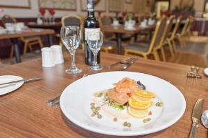 a plate of food on a table with a bottle of wine at Salutation Hotel in Perth