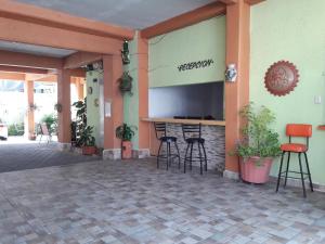 a lobby with a bar with stools and a tv at Oaxaquita la Bella in Oaxaca City