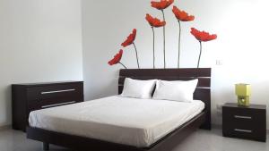 ピッツォにあるApartment Olgaのベッドルーム1室(赤い花の壁にベッド1台付)