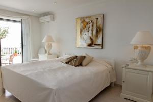 ミハス・コスタにあるVilla Azaleaの白いベッドルーム(大型ベッド1台、窓付)