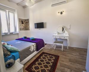 a bedroom with a bed and a desk and a mirror at Emma's rooms B&B in Pula
