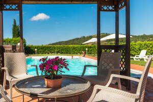 a patio with a table and chairs and a pool at Agriturismo Pian del Vescovo in Massa Marittima