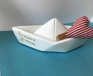 una piccola barca bianca con un fiocco rosso e bianco di Residence Giuliana a Leuca