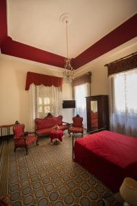 duża sypialnia z czerwonym łóżkiem i krzesłami w obiekcie Villa le Torri B&B w Trapani
