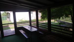 eine Veranda mit einem Tisch und Blick auf einen Hof in der Unterkunft Puszta Hotel in Berekfürdő
