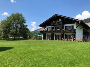 a large building with a grass field in front of it at Hotel Bachmair Alpina in Rottach-Egern