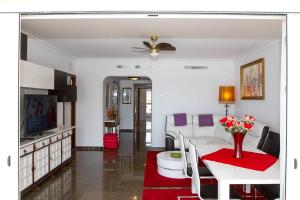 sala de estar con mesa blanca y alfombra roja en Carihuela, en Torremolinos