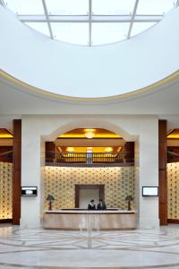 Crowne Plaza - Dubai Jumeirah, an IHG Hotel في دبي: جلوس شخصين في بهو مبنى