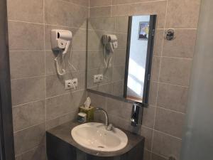 La salle de bains est pourvue d'un lavabo et d'un téléphone mural. dans l'établissement Apart-Hotel Shell, à Tbilissi