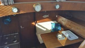 einen Blick über ein Boot mit einem Tisch und Uhren in der Unterkunft Lady of Bahia in Marseillan