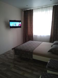 a bedroom with a bed and a television on the wall at Подобово апартаменти в м Буча in Bucha