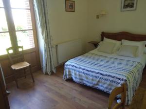 ein Schlafzimmer mit einem Bett, einem Stuhl und einem Fenster in der Unterkunft La Ferme de Mezoutre in Vironchaux