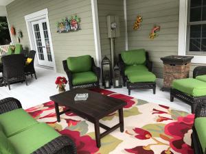 a patio with green chairs and a table on a porch at Lamp Lighter Mountain Inn in Zirconia