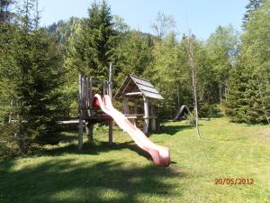 a playground with a pink slide in a field at Huberbauer in Johnsbach