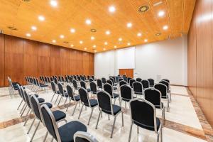 uma sala com filas de cadeiras numa sala de conferências em Eurostars San Lazaro em Santiago de Compostela