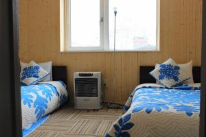 a bedroom with two beds and a air conditioner at Pension Fryingpan in Niseko +190 photos