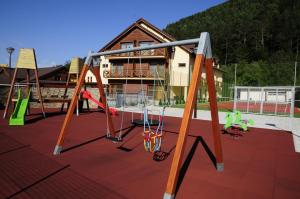 an empty playground with swings and a building at Country Saloon Belá in Svit