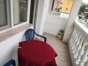 a table and a chair with a red cloth on a balcony at Anele,Kiten in Kiten