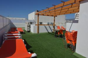 a patio with orange chairs and a table on a roof at Armonía Beach 17 in Arinaga