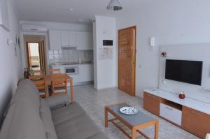 a living room with a couch and a table and a kitchen at Armonía Beach 17 in Arinaga