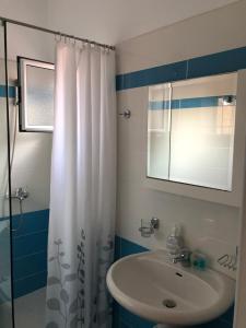 a bathroom with a sink and a shower curtain at Sunset Apartments Berdenesh Sarandë in Sarandë +112 photos