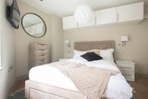 a bedroom with a large bed and a mirror at The New Bond Street Loft - Modern & Central 1BDR in London