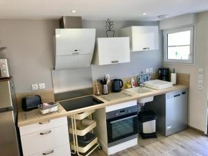 a kitchen with white cabinets and a counter top at Gîte Bambou in Seigy