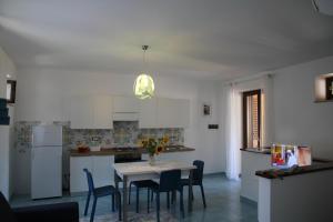 a kitchen with a table and chairs in a kitchen at Malvasia - Case Vacanza Il Palmento in Canneto +10 photos