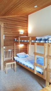 a bedroom with two bunk beds and a chair at Bjursås Berg & Sjö in Bjursås