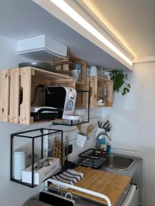 a kitchen with a counter with wooden cabinets and a sink at Casa nostra Capodistria in Koper