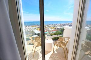 Un balcón con sillas y vistas al océano. en Hotel Daniel's FRONTE MARE, en Riccione