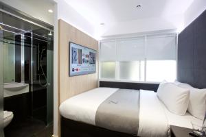 The Z Hotel Tottenham Court Road في لندن: غرفة نوم بسرير وحمام مع مرحاض