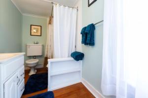a bathroom with a toilet and a white shower curtain at The Elmhurst Inn in Bar Harbor