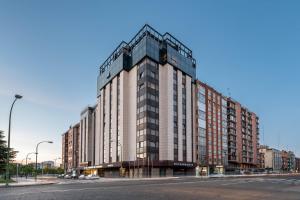 ein großes Gebäude auf einer Straße mit einer Straße in der Unterkunft Crisol Puerta de Burgos in Burgos