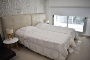 1 dormitorio con 1 cama con sábanas blancas y ventana en Loft para 4 personas 2º B en Buenos Aires