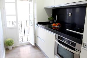 a kitchen with white cabinets and a black counter top at Sopranis by Gades Gestión in Cádiz