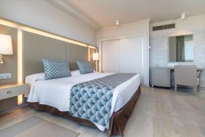 a hotel room with a large bed and a desk at Spring Hotel Vulcano in Playa de las Americas