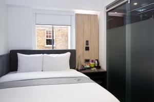 a bedroom with a white bed and a window at The Z Hotel Tottenham Court Road in London