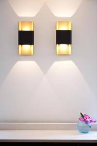 two lights on a wall with a vase of flowers at The Z Hotel Tottenham Court Road in London