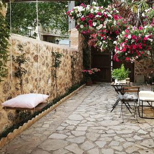 een patio met een tafel, stoelen en bloemen bij Patio de las Flores in Riópar