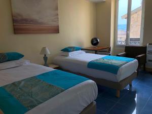 a hotel room with two beds and a window at Aston - Appartement Centre Ville Massena in Nice