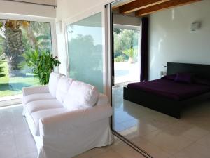 un soggiorno con divano bianco e letto di Villa Belvedere Degli Ulivi a Osimo